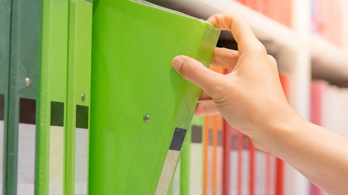 image of a hand taking a folder off a shelf